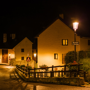 Perspectiva nocturna de las calles, destacando la luz cálida y acogedora para vecinos y visitantes.