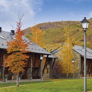 Golden hues in deciduous trees, with rolling hills in the background and traditional buildings flanked by Villa luminaires